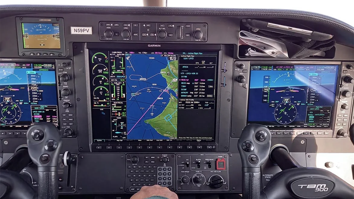 Glass-cockpit instrument panel and control yokes during a navigation training flight